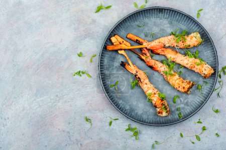Photo for Tasty shrimp barbecue with herbs fried on wooden sticks. Prawns skewers. Space for text - Royalty Free Image