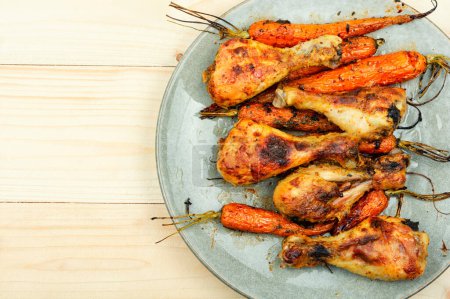 Photo for Grilled chicken drumsticks, roast chicken legs with carrots. Copy space - Royalty Free Image