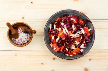 Photo for Salad with chicory, grapefruit and pine nuts on wooden table. Radicchio salad - Royalty Free Image