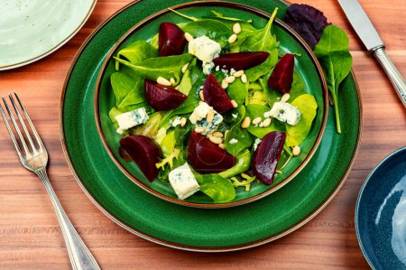 Téléchargez les photos : Salade de betteraves avec betteraves, fromage bleu, herbes et pignons dans l'assiette verte - en image libre de droit