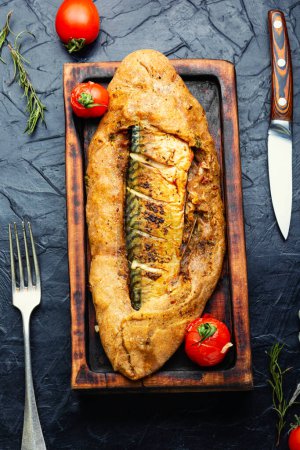 Foto de Delicioso pastel de pescado con caballa o scomber en la tabla de cortar. Vista superior - Imagen libre de derechos