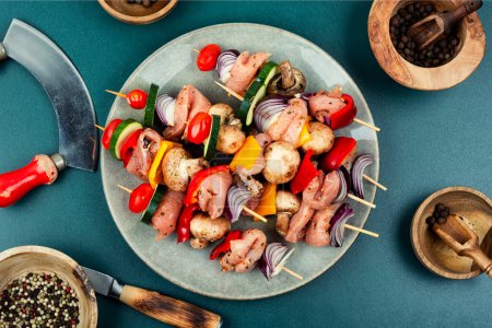 Téléchargez les photos : Brochettes fraîches avec morceaux de viande crue et légumes marinés aux herbes. Shashlik cru et légumes - en image libre de droit