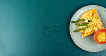 Foto de Sabrosa tortilla con espárragos verdes, salsa y microgreens. Banner. Copiar espacio. - Imagen libre de derechos