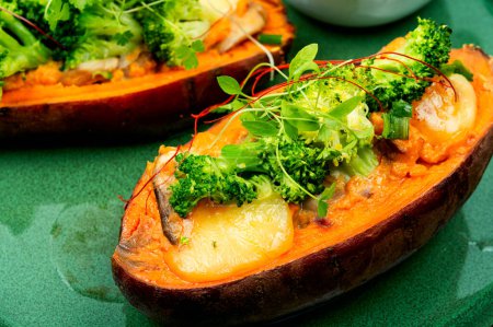 Téléchargez les photos : Plat végétarien, patate douce au four farcie aux champignons, brocoli et poivrons. - en image libre de droit