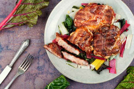 Téléchargez les photos : Steak de viande rôtie juteuse sur un oreiller de légumes. - en image libre de droit