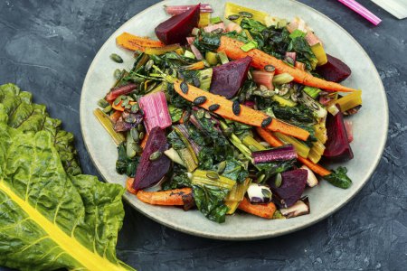 Foto de Ensalada de acelgas guisadas, remolacha y zanahorias con semillas de calabaza. Concepto de comida saludable vegetariana - Imagen libre de derechos