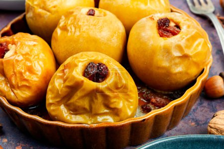 Téléchargez les photos : Délicieuses pommes d'automne cuites au four aux noix et raisins secs - en image libre de droit