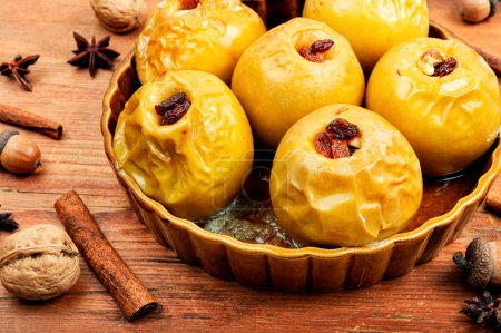 Baked autumn apples stuffed with nuts, cinnamon and raisins. Rustic style.