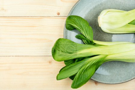 Photo for Fresh bok choy or chinese cabbage on rustic wooden background. Space for text - Royalty Free Image