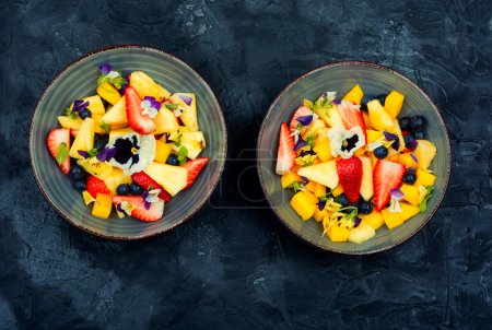 Photo for Salad of pineapple and berries, decorated with edible flowers. Low carb diet - Royalty Free Image