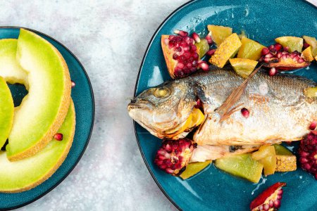 Photo for Baked dorado fish or gilt-head bream with melon on a light background. Healthy food - Royalty Free Image