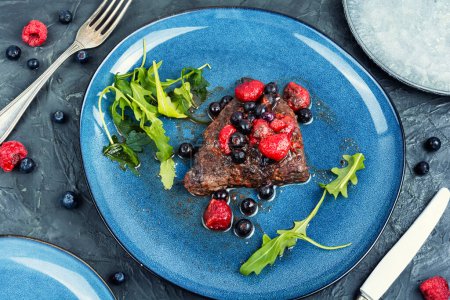 Photo for Beef steak roasted in blueberry and raspberry sauce. Top view. - Royalty Free Image