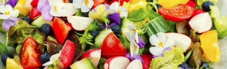 Foto de Ensalada de verduras brillantes con flores comestibles. Comer limpio. Primer plano, fondo alimentario - Imagen libre de derechos