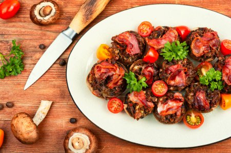 Téléchargez les photos : Champignon maison farci à la viande hachée, tomates et bacon sur fond bois. Pose plate. - en image libre de droit