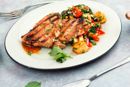 Foto de Filete de atún asado servido con ensalada en un plato. Alimento dietético - Imagen libre de derechos