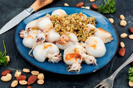 Téléchargez les photos : Jeunes calmars cuits au four ou calamars avec garniture de noix. Corée nourriture traditionnelle. - en image libre de droit