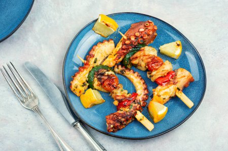 Photo for Skewers of octopus and squid on plate. Grilled octopus tentacle. Sea delicacy. - Royalty Free Image