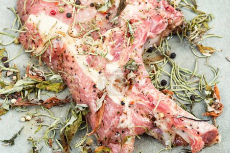 Foto de Filete de cerdo fresco crudo Tomahawk marinado en hierbas especiadas. De cerca. - Imagen libre de derechos