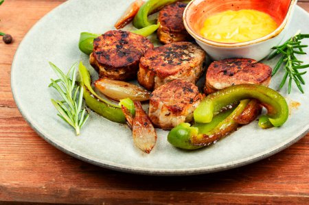 Téléchargez les photos : Portion de médaillons juteux steaks avec poivrons dans une assiette. - en image libre de droit