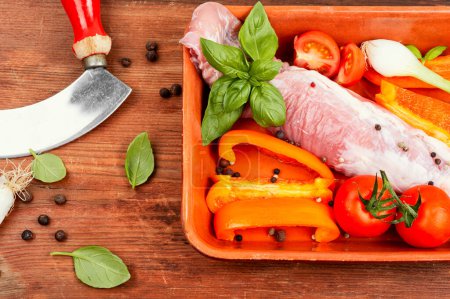 Photo for Fresh pork tenderloin with vegetables in a baking dish on wooden background. - Royalty Free Image