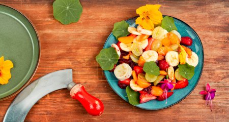 Photo for Healthy fresh fruit salad with banana, strawberries, grapes and nasturtium - Royalty Free Image