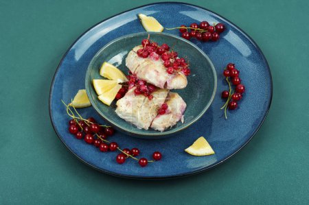 Téléchargez les photos : Filet de morue sans peau cuit avec des groseilles rouges. Morue, poisson blanc. - en image libre de droit