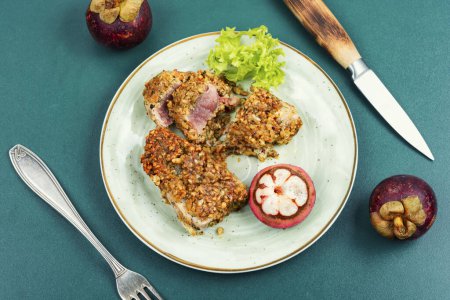 Téléchargez les photos : Steak de thon cuit dans une noix avec un mangoustan. Alimentation diététique. Pose plate. - en image libre de droit
