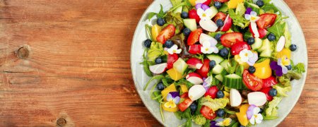 Téléchargez les photos : Salade de légumes aux fleurs comestibles. Espace de copie, lieu de recette. - en image libre de droit