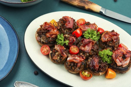 Photo for Appetizing champignon mushrooms stuffed with vegetables, minced meat and bacon. - Royalty Free Image