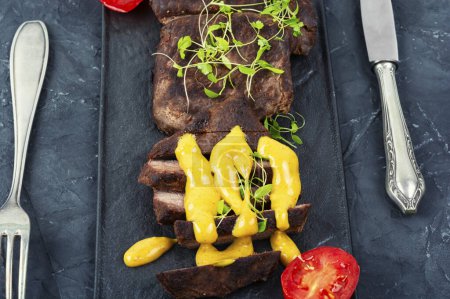 Photo for Roasted ostrich meat steaks with sauce. African cuisine. - Royalty Free Image
