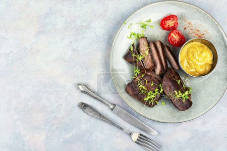 Téléchargez les photos : Steaks d'autruche rôtis avec sauce. Cuisine africaine. Espace de copie - en image libre de droit
