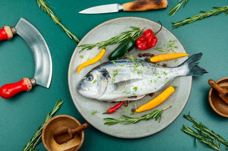 Foto de Pescado dorado crudo y especias para cocinar e ingredientes alimentarios en la mesa - Imagen libre de derechos