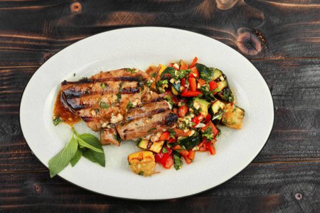 Foto de Filete de atún cocido con verduras en mesa de madera. Mariscos. - Imagen libre de derechos