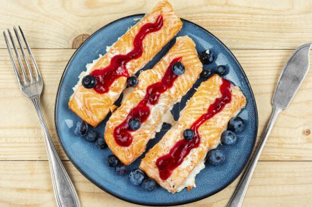 Photo for Baked salmon fish with blueberry berry sauce. Salmon fillets, grilled steaks. Top view. - Royalty Free Image