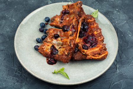 Photo for Fried pork ribs with blueberry sauce on a stone background - Royalty Free Image