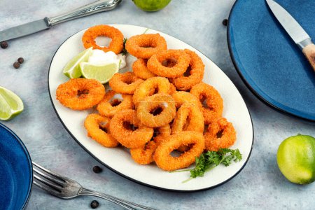 Téléchargez les photos : Calamars frits croustillants ou anneaux de calmar. Délicieux fruits de mer frits - en image libre de droit