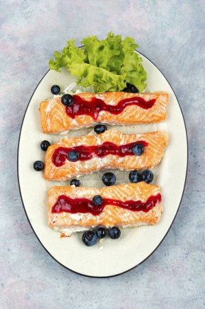 Photo for Baked salmon fillet with blueberry berry sauce. Top view. - Royalty Free Image