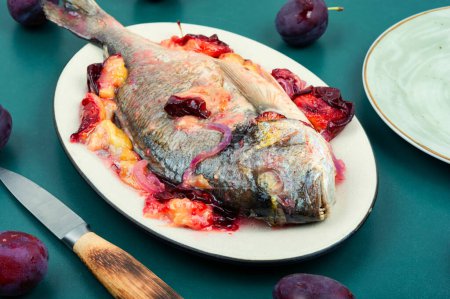 Photo for Dorado or sea bream fish baked with plums. Gilthead fishes - Royalty Free Image