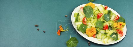 Téléchargez les photos : Salade végétalienne verte aux feuilles vertes, légumes et rhinturtium comestible. Espace pour le texte. - en image libre de droit