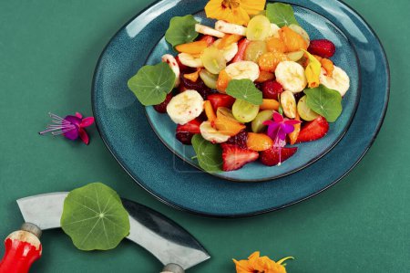Photo for Colorful salad of fresh fruits and edible nasturtium leaves. Healthy diet food - Royalty Free Image
