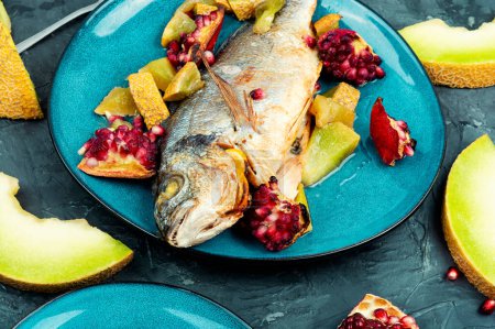 Photo for Baked dorado fish with melon and pomegranate. Whole grilled fish on plate - Royalty Free Image