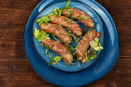 Photo for Fried sausage on plate on a wooden background. Barbecue bratwurst, top view. - Royalty Free Image