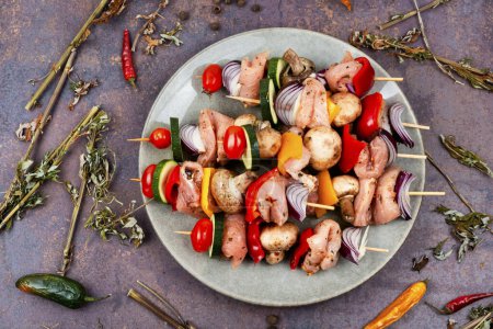 Téléchargez les photos : Brochettes avec morceaux de viande crue et légumes. Barbecue viande épices et herbes. - en image libre de droit