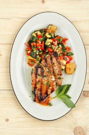 Téléchargez les photos : Bifteck de thon grillé avec des légumes cuits au four dans une assiette. Aliments diététiques - en image libre de droit