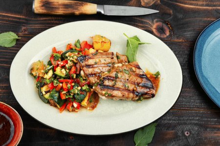 Téléchargez les photos : Steak de thon grillé aux légumes cuits au four sur table rustique en bois - en image libre de droit
