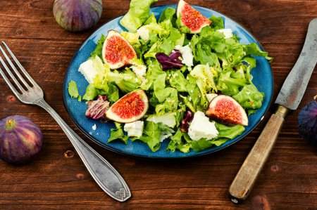 Téléchargez les photos : Salade de légumes verts, figues mûres et fromage diététique sur une surface rustique en bois. Saladier fait maison - en image libre de droit