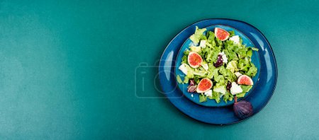 Photo for Vitamin dietetic salad of greens, ripe figs and diet cheese. Copy space - Royalty Free Image