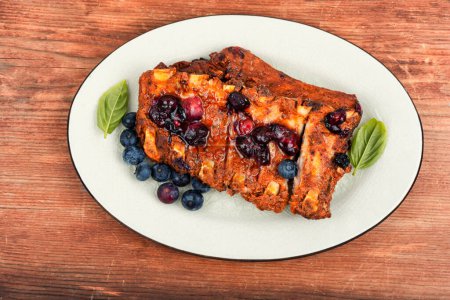Photo for Barbecue pork spare loin ribs with blueberry sauce on old vintage wooden table - Royalty Free Image