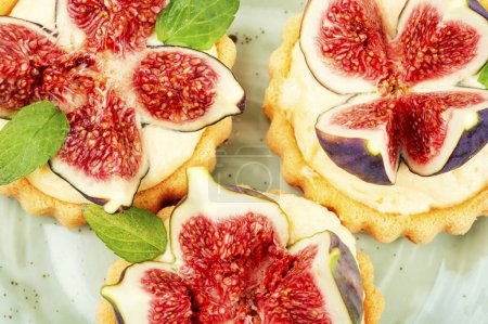 Photo for Freshly backed tartlet dessert with figs and custard on a plate. Closeup of delicious sweets - Royalty Free Image