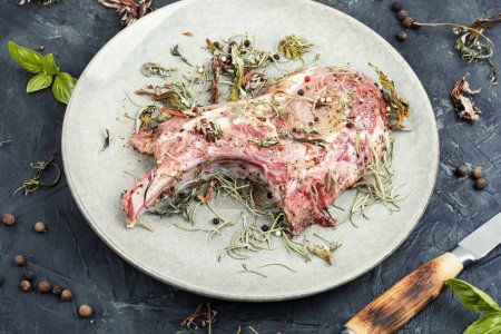 Téléchargez les photos : Bifteck de porc cru Tomahawk mariné aux herbes épicées sur fond de pierre - en image libre de droit